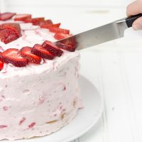 Fresh Strawberry Cake | This cake features loads of fresh strawberries and a light whipped cream topping. It's PERFECT for summer!!