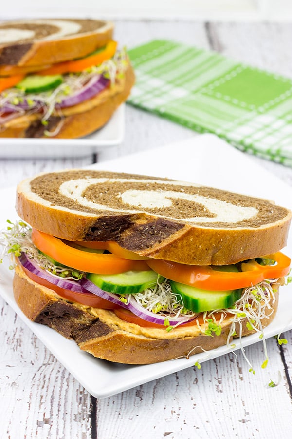 These Sun-Dried Tomato and Garlic Hummus Sandwiches are loaded with delicious, creamy hummus and fresh, crispy veggies. They're the perfect summer lunch!