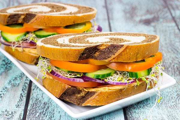 These Sun-Dried Tomato and Garlic Hummus Sandwiches are loaded with delicious, creamy hummus and fresh, crispy veggies. They're the perfect summer lunch!