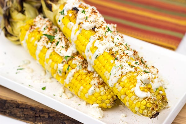 This Mexican Street Corn is covered in crema, grated Parmesan, lime juice and feta cheese. It's messy...and VERY tasty!