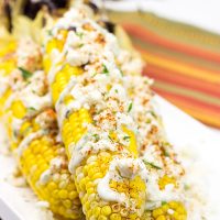 This Mexican Street Corn is covered in crema, grated Parmesan, lime juice and feta cheese. It's messy...and VERY tasty!