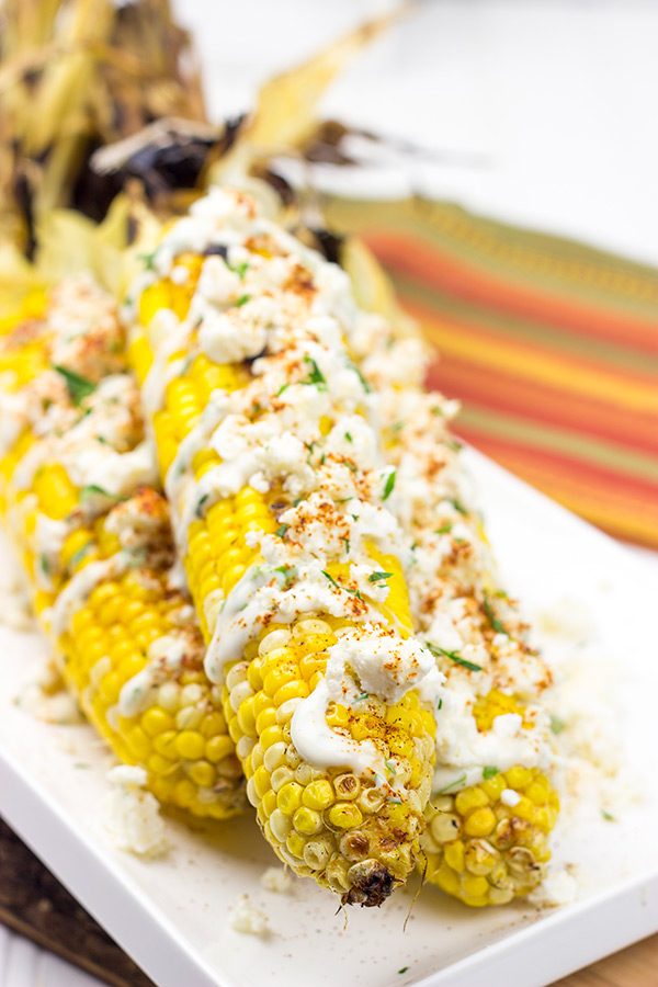 This Mexican Street Corn is covered in crema, grated Parmesan, lime juice and feta cheese. It's messy...and VERY tasty!