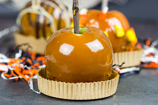 Homemade caramel apples are an easy and fun seasonal treat! Grab some juicy apples and top them with caramel, chocolate and chopped nuts. #ad #WalmartProduce