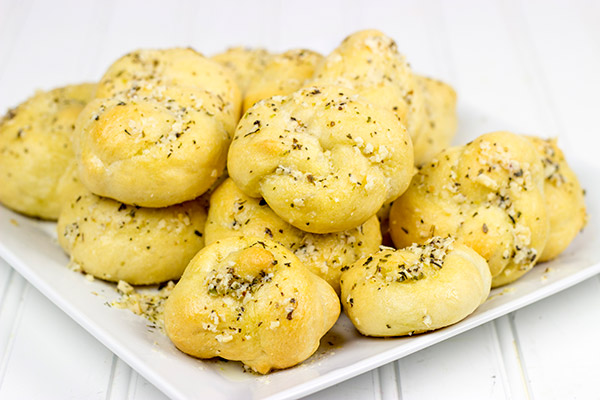 Brushed with melted butter, minced garlic and shaved Parmesan cheese, these Parmesan Garlic Knots are a delicious appetizer for gameday!