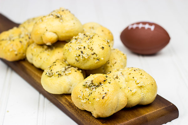Brushed with melted butter, minced garlic and shaved Parmesan cheese, these Parmesan Garlic Knots are a delicious appetizer for gameday!