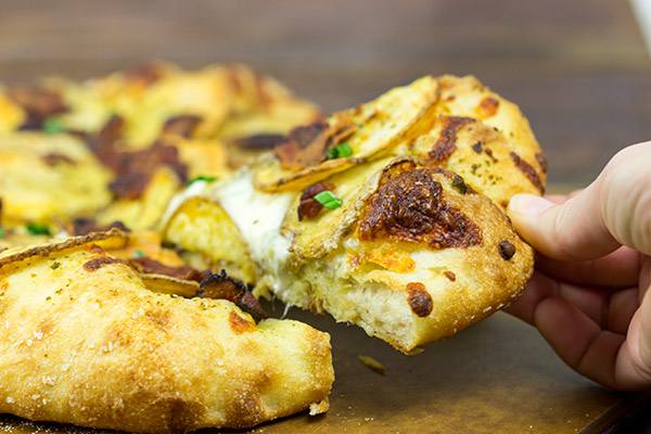 Looking for a delicious and unique pizza topping? Try some spuds! This Roasted Potato, Bacon and Onion Pizza is the perfect comfort food on a cold night!