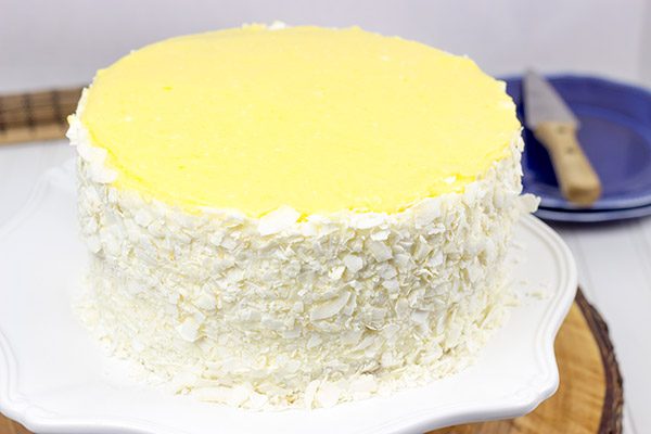 Decadent coconut flakes...sweet vanilla buttercream...tart lemon curd. One slice of this Lemon Coconut Cake will whisk you away to a warm Caribbean island!