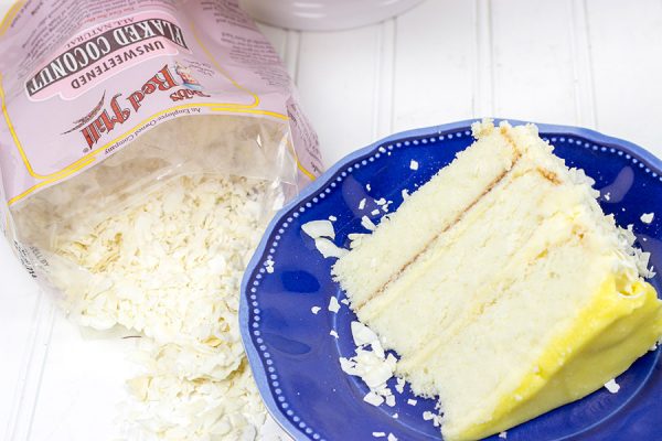 Decadent coconut flakes...sweet vanilla buttercream...tart lemon curd. One slice of this Lemon Coconut Cake will whisk you away to a warm Caribbean island! 