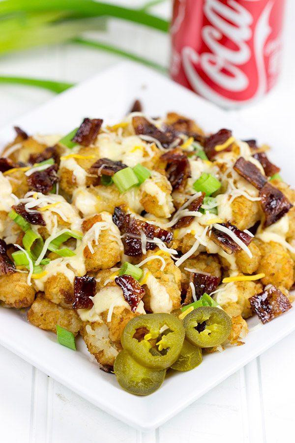 These Loaded Tots are topped with a tasty queso cheese sauce and Coca-Cola glazed bacon bits! They're the perfect snack for watching sports!