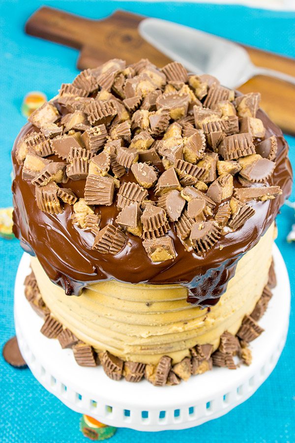 This Reese's Chocolate Peanut Butter Cake features a rich, moist chocolate cake covered in a decadent peanut butter frosting. Garnish with chopped peanut butter cups for a delicious dessert!