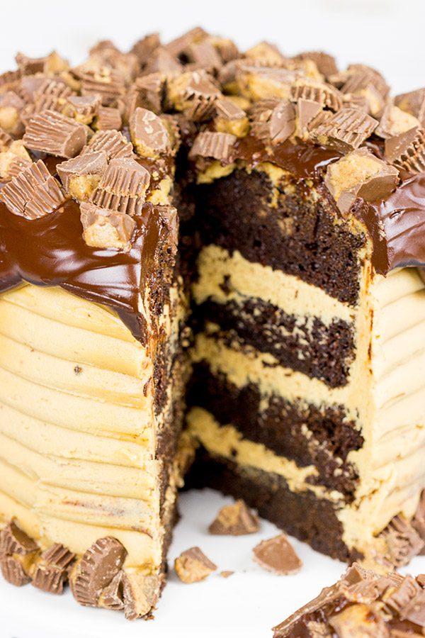 This Reese's Chocolate Peanut Butter Cake features a rich, moist chocolate cake covered in a decadent peanut butter frosting. Garnish with chopped peanut butter cups for a delicious dessert!