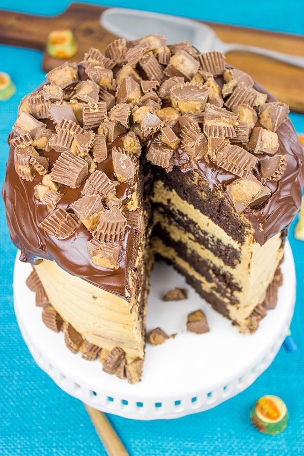This Reese's Chocolate Peanut Butter Cake features a rich, moist chocolate cake covered in a decadent peanut butter frosting. Garnish with chopped peanut butter cups for a delicious dessert!