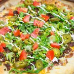 Topped with seasoned beef and your favorite taco ingredients, this Taco Pizza is a delicious way to celebrate the arrival of warm(er) weather!