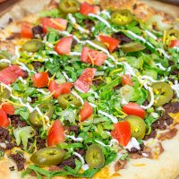 Topped with seasoned beef and your favorite taco ingredients, this Taco Pizza is a delicious way to celebrate the arrival of warm(er) weather!