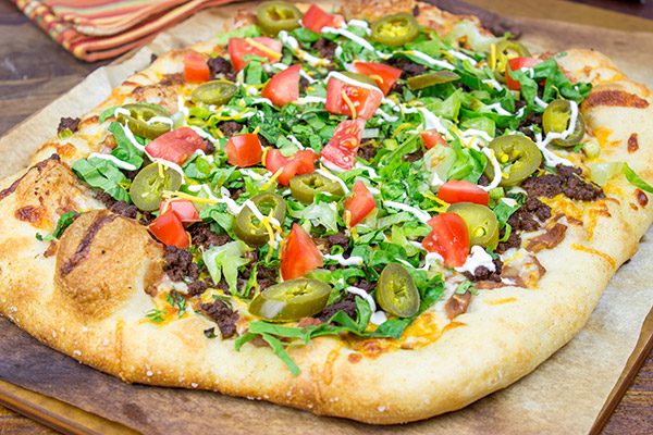 Topped with seasoned beef and your favorite taco ingredients, this Taco Pizza is a delicious way to celebrate the arrival of warm(er) weather!