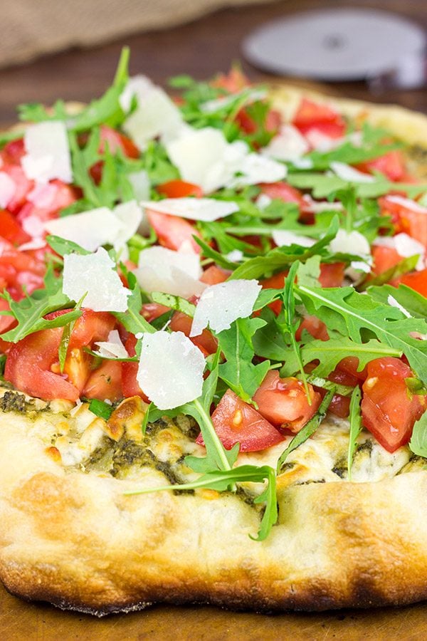 Brushed with pesto and then topped with fresh tomatoes and arugula, this Bruschetta Pizza is a delicious summer meal!