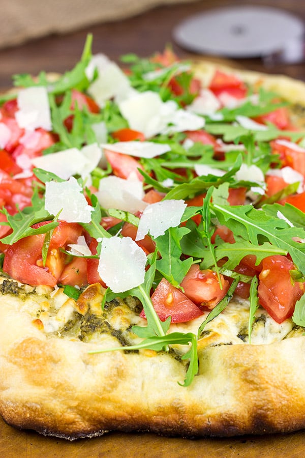 Brushed with pesto and then topped with fresh tomatoes and arugula, this Bruschetta Pizza is a delicious summer meal!