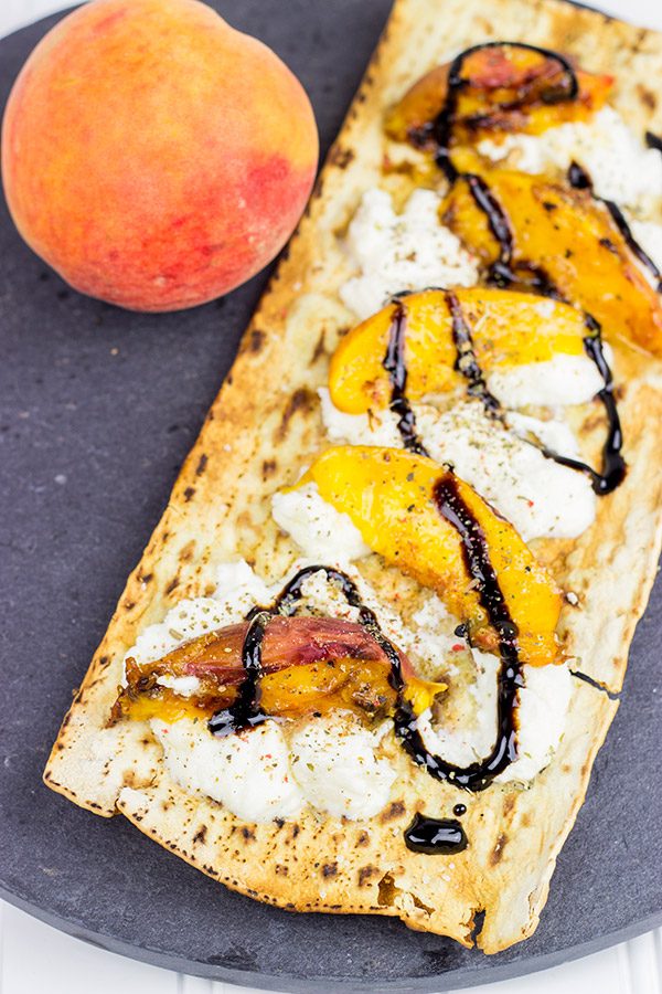 Grab some fresh peaches and toss 'em on the grill! This Grilled Peach and Ricotta Flatbread makes for one awesome summer meal!