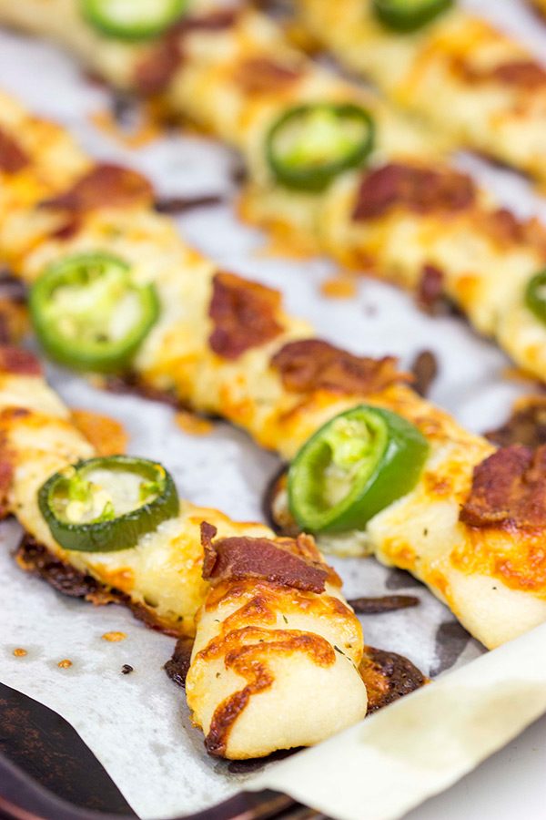 Topped with bacon, jalapenos and two types of cheese, these Bacon Jalapeno Cheesy Breadsticks are an easy and delicious gametime snack!