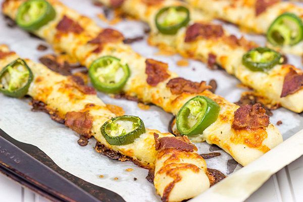 Topped with bacon, jalapenos and two types of cheese, these Bacon Jalapeno Cheesy Breadsticks are an easy and delicious gametime snack!