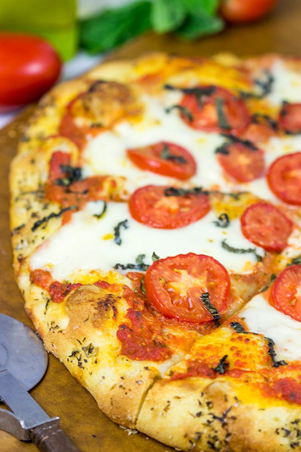 This Classic Pizza Margherita features slices of Roma tomatoes and fresh mozzarella. This recipe is perfect for curling up on the couch and watching a movie!