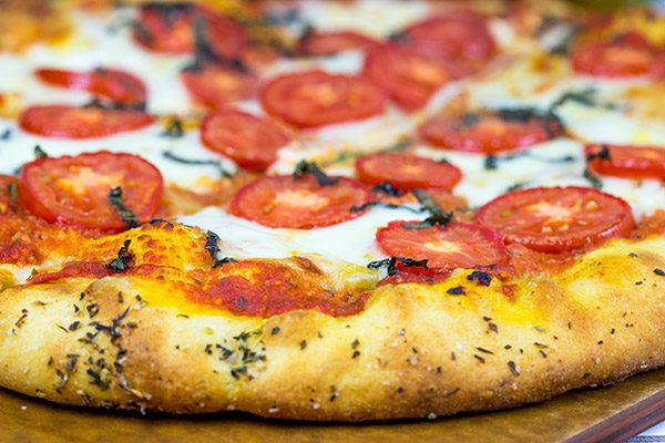 This Classic Pizza Margherita features slices of Roma tomatoes and fresh mozzarella. This recipe is perfect for curling up on the couch and watching a movie!
