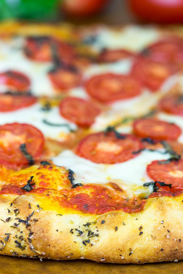 This Classic Pizza Margherita features slices of Roma tomatoes and fresh mozzarella. This recipe is perfect for curling up on the couch and watching a movie!