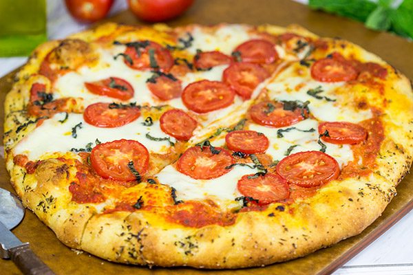 This Classic Pizza Margherita features slices of Roma tomatoes and fresh mozzarella. This recipe is perfect for curling up on the couch and watching a movie!