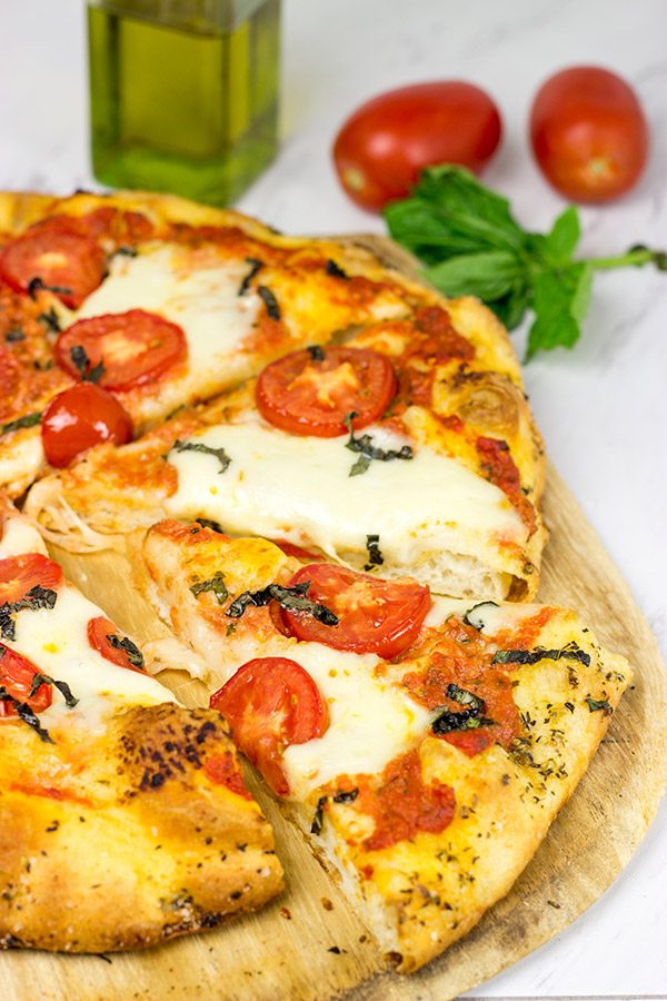This Classic Pizza Margherita features slices of Roma tomatoes and fresh mozzarella. This recipe is perfect for curling up on the couch and watching a movie!