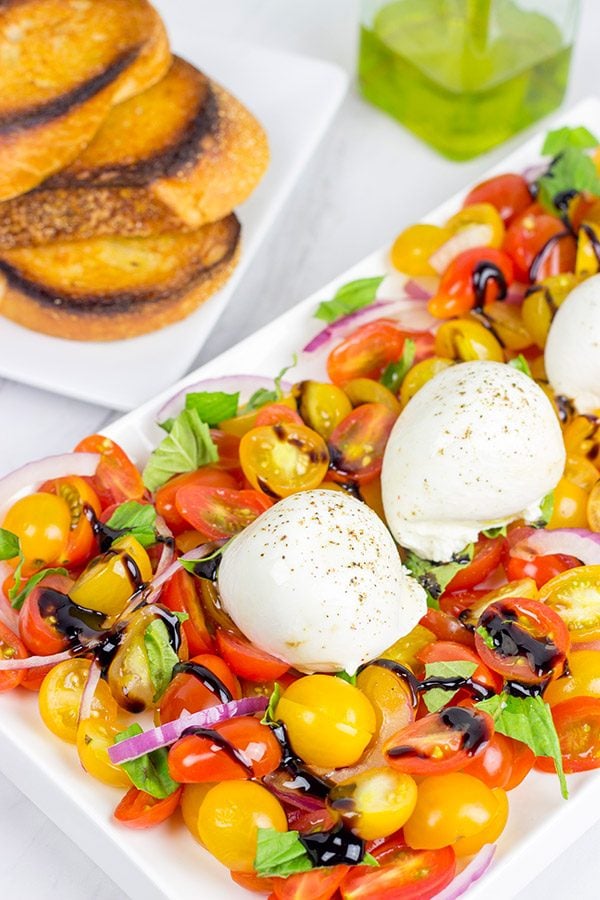 Ever tried burrata cheese? It's in the mozzarella family, and it makes for a great centerpiece of this Tomato and Burrata Caprese!