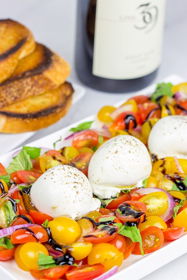 Ever tried burrata cheese? It's in the mozzarella family, and it makes for a great centerpiece of this Tomato and Burrata Caprese!