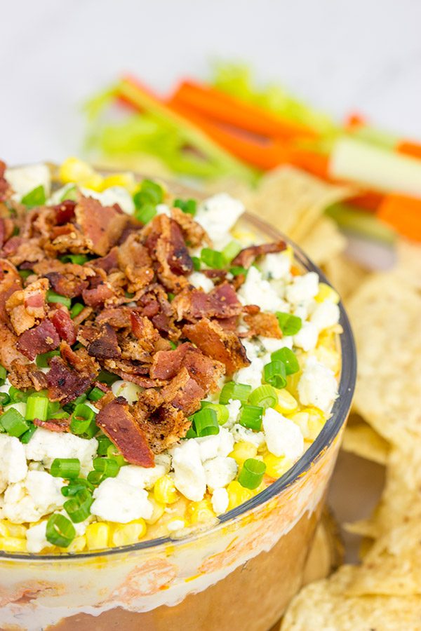 Complete with spicy buffalo chicken, creamy refried beans and crunchy bacon, this 7-Layer Buffalo Chicken Dip is a surefire party favorite!