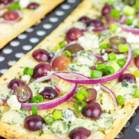 Featuring a sweet + savory combo of red grapes and blue cheese, these Blue Cheese and Roasted Grape Flatbread Pizzas make for an easy gourmet dinner!