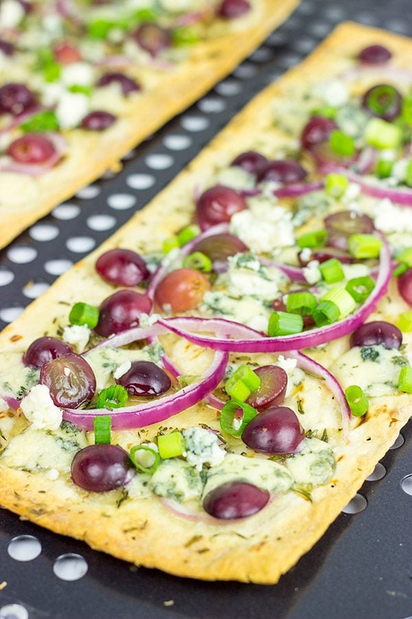 Featuring a sweet + savory combo of red grapes and blue cheese, these Blue Cheese and Roasted Grape Flatbread Pizzas make for an easy gourmet dinner!