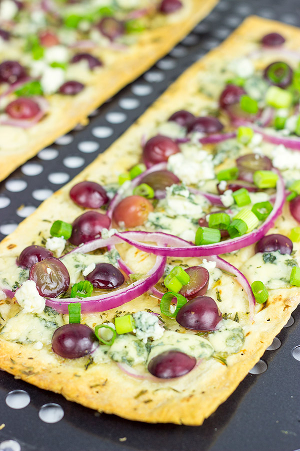 Featuring a sweet + savory combo of red grapes and blue cheese, these Blue Cheese and Roasted Grape Flatbread Pizzas make for an easy gourmet dinner!