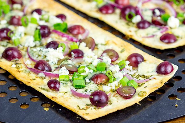 Featuring a sweet + savory combo of red grapes and blue cheese, these Blue Cheese and Roasted Grape Flatbread Pizzas make for an easy gourmet dinner!