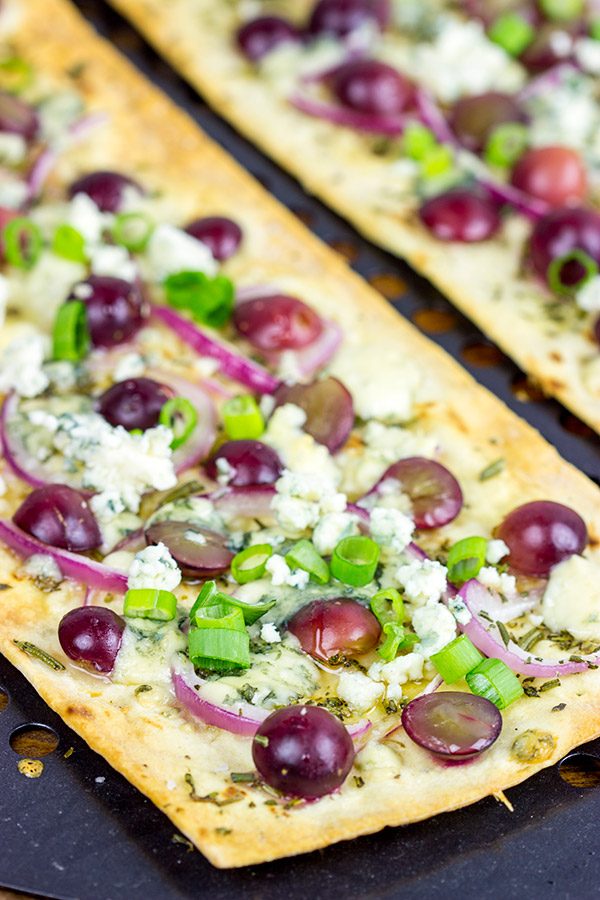 Featuring a sweet + savory combo of red grapes and blue cheese, these Blue Cheese and Roasted Grape Flatbread Pizzas make for an easy gourmet dinner!