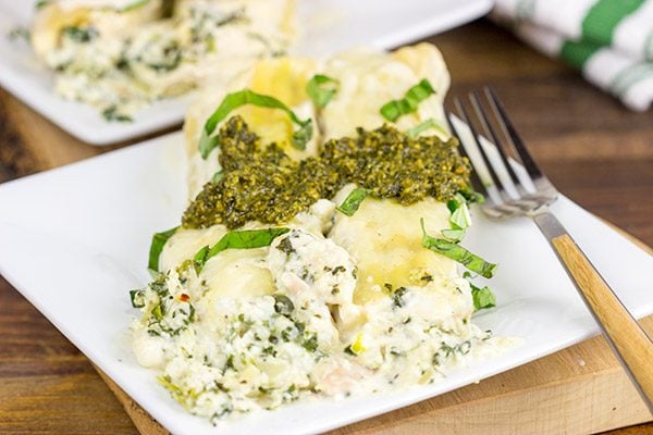 This tasty Pesto Chicken Manicotti is baked in a creamy alfredo sauce and then topped with fresh basil pesto!