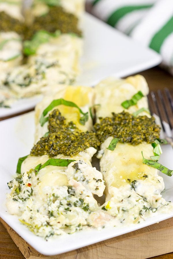 This tasty Pesto Chicken Manicotti is baked in a creamy alfredo sauce and then topped with fresh basil pesto!