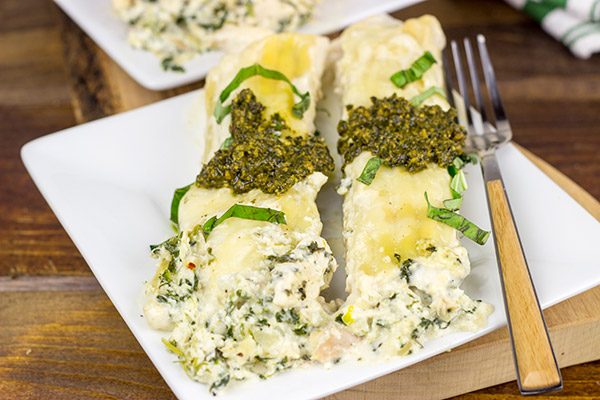 This tasty Pesto Chicken Manicotti is baked in a creamy alfredo sauce and then topped with fresh basil pesto!
