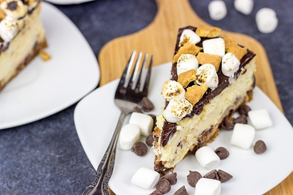 It might be chilly outside, but this S'mores Cheesecake is loaded with chocolate, marshmallow and graham crackers...and it's sure to remind you of a summer campfire!