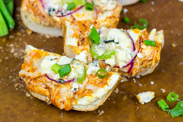 These Buffalo Chicken Breadsticks make an excellent football appetizer!  Grab a loaf of French bread and top it with spicy buffalo chicken, creamy blue cheese and melty mozzarella!