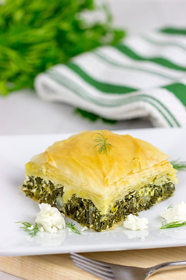 Spanakopita is a classic Greek recipe featuring layers of flaky dough stuffed with spinach and feta cheese...and it's delicious!