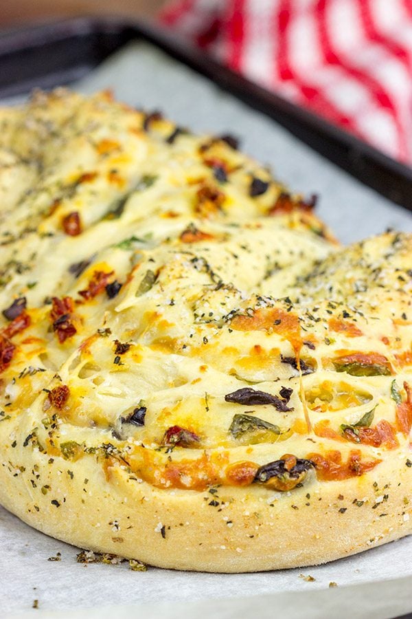 This Stuffed Italian Bread is so much fun to make...and even more fun to eat!  It's packed with mozzarella, Parmesan, sundried tomatoes and kalamata olives!