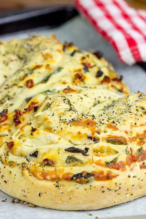 This Stuffed Italian Bread is so much fun to make...and even more fun to eat! It's packed with mozzarella, Parmesan, sundried tomatoes and kalamata olives!