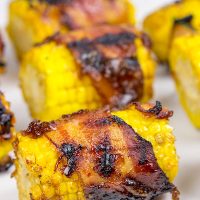 Hunting for a fun side dish for summer grilling? This Bacon Wrapped Corn with Honey BBQ Sauce is a winner!