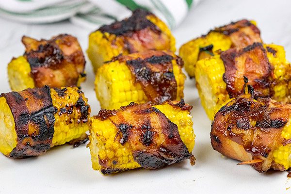 Hunting for a fun side dish for summer grilling?  This Bacon Wrapped Corn with Honey BBQ Sauce is a winner!