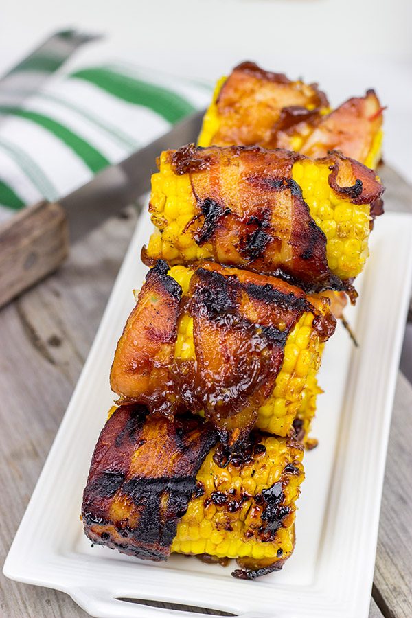 Hunting for a fun side dish for summer grilling?  This Bacon Wrapped Corn with Honey BBQ Sauce is a winner!