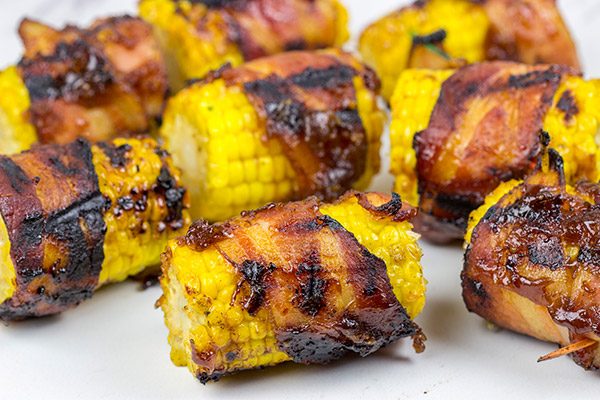 Hunting for a fun side dish for summer grilling?  This Bacon Wrapped Corn with Honey BBQ Sauce is a winner!