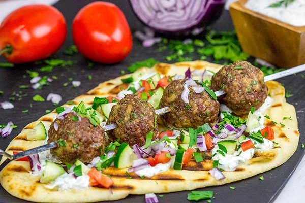These Mediterranean Meatball Kabobs deserve a spot on your dinner menu soon!  Served up with grilled naan and a bit of tzatziki sauce, these meatballs are sure to become a favorite in your house, too!